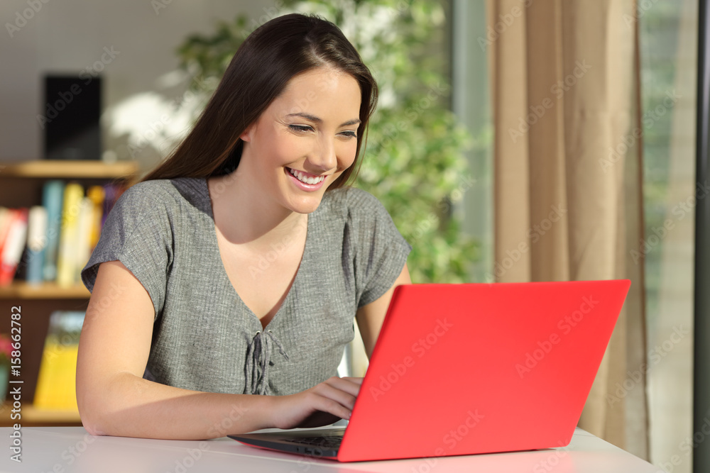 Writer writing in a red laptop at home Writer writing in a red laptop at home