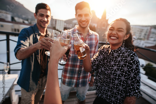 Friends toasting drinks on a rooftop