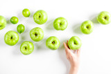 ripe green apples with hands white table background top view