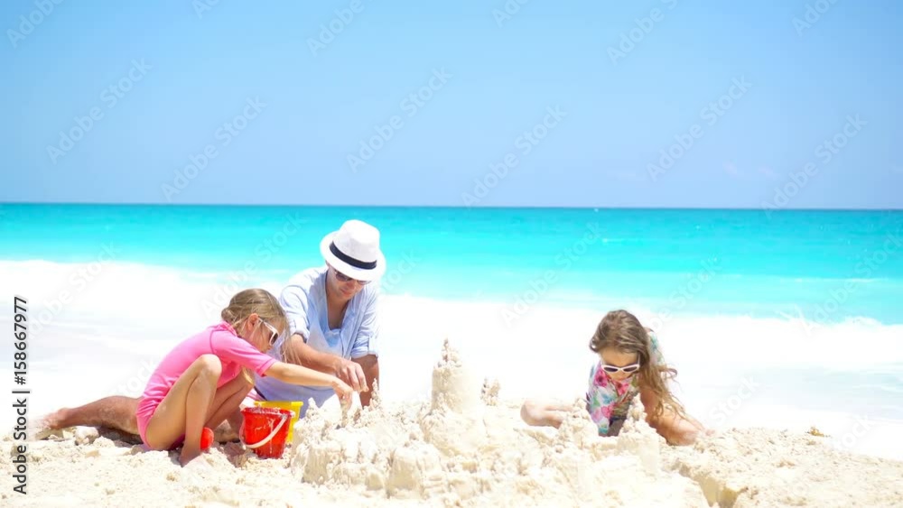 Father and little kids making sand castle at tropical beach Father and little kids making sand castle at tropical beach