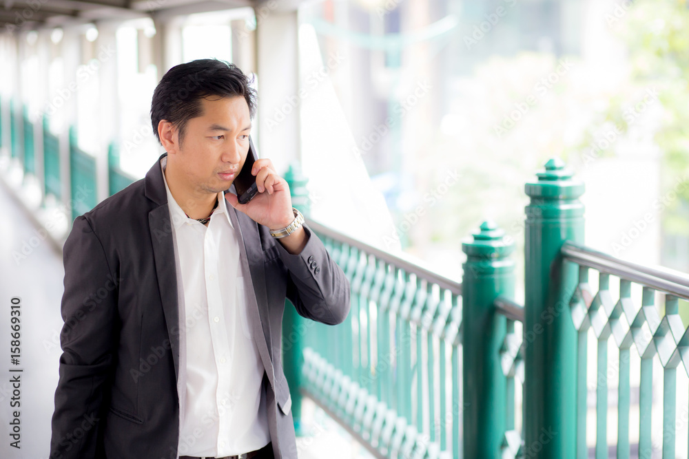 Portrait of a confident business man talking cell phone call outdoor. Portrait of a confident business man talking cell phone call outdoor.