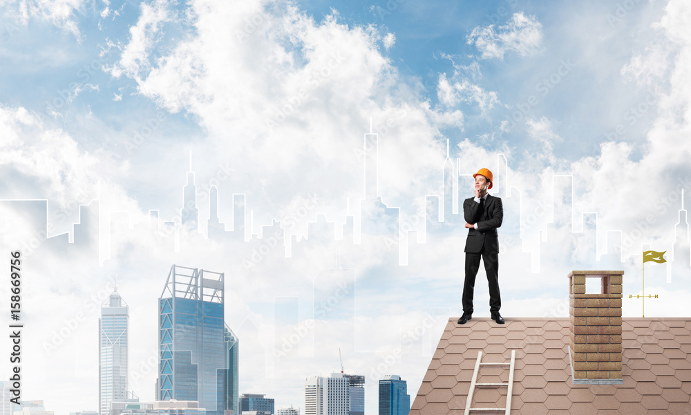 Engineer man standing on roof and looking away. Mixed media Engineer man standing on roof and looking away. Mixed media