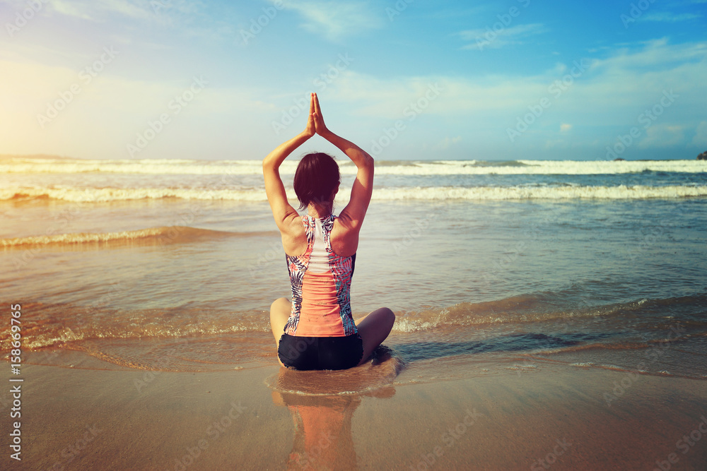 Young fitness woman wear swimsuit practice yoga on the beach