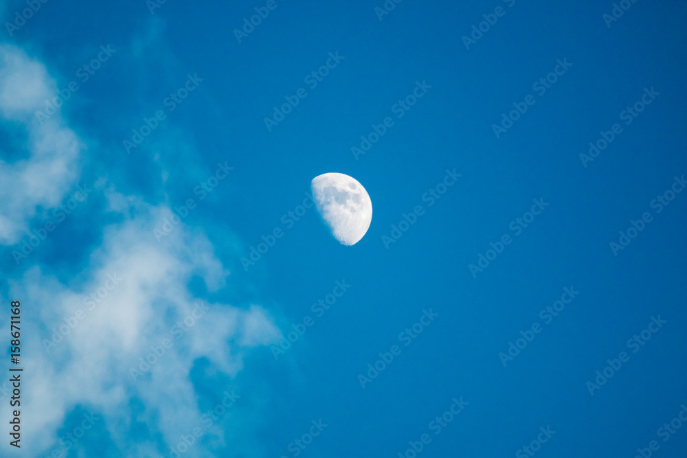 Moon and clouds in the deep blue sky during the day. Moon and clouds in the deep blue sky during the day.