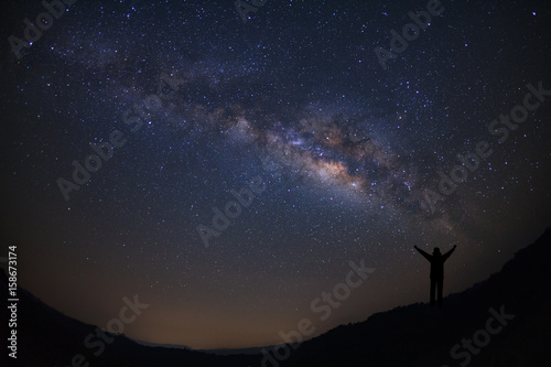 Landscape with milky way, Night sky with stars and silhouette of happy people standing on moutain, Long exposure photograph, with grain. © sripfoto