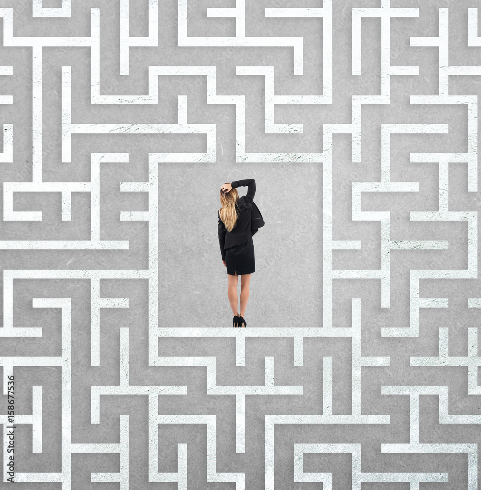 Confused businesswoman at the center of a maze Confused businesswoman at the center of a maze
