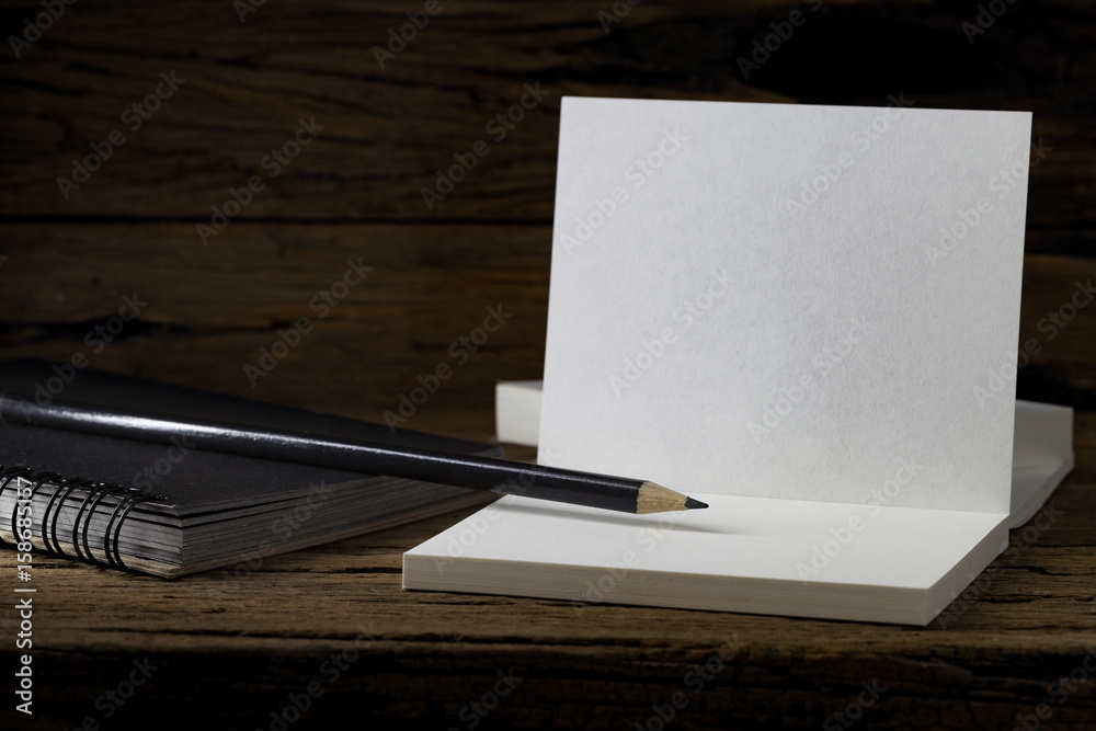 Pencil with white business paper on dark wooden table background. Pencil with white business paper on dark wooden table background.