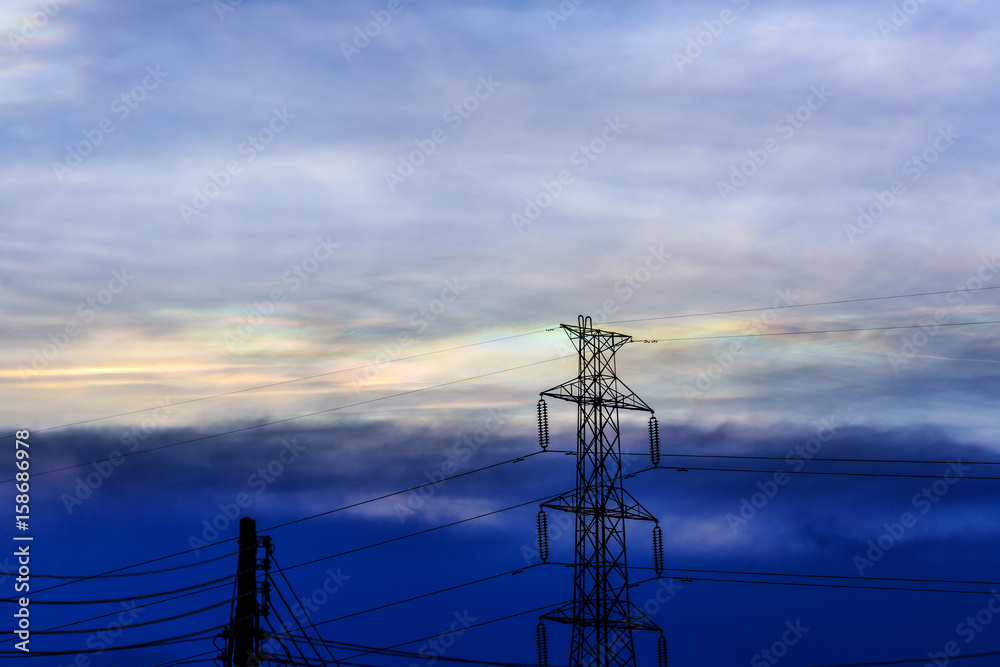 Electric pole high voltage with sky burst and rainbow cloud in background
