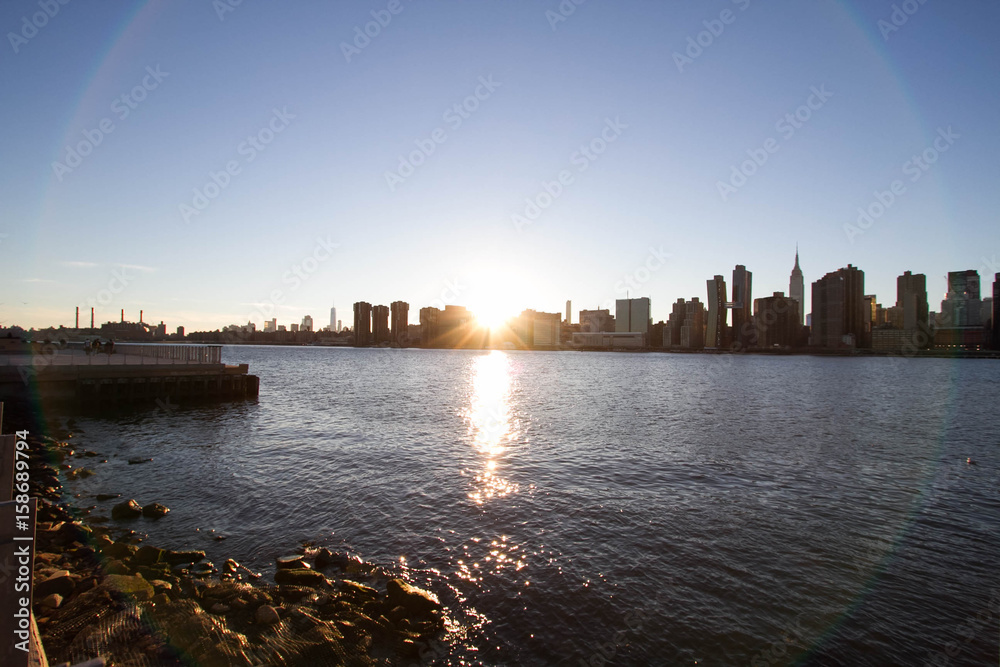 Sunset behind Manhattan reflects on East river