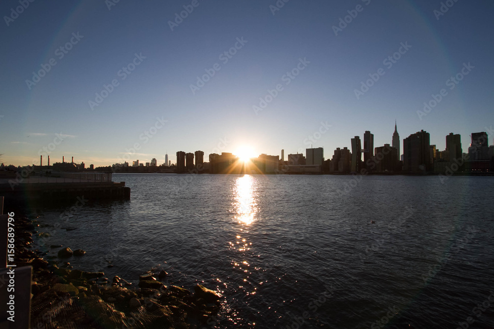 Sunset behind Manhattan reflects on East river