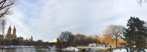 Bow bridge and lake with snow at Central Park in panorama view, New York