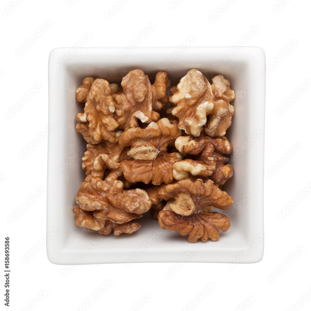 Roasted walnut in a square bowl isolated on white background Roasted walnut in a square bowl isolated on white background