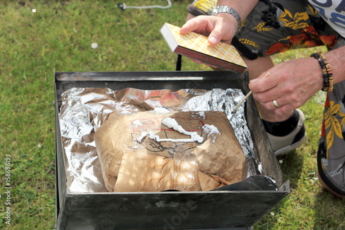 Starting a barbecue with a bag of instant lighting lumpwood charcoal for cooking outside photo