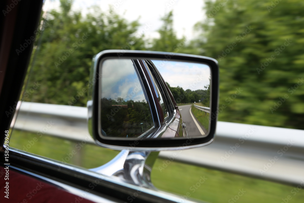 Road in car mirror