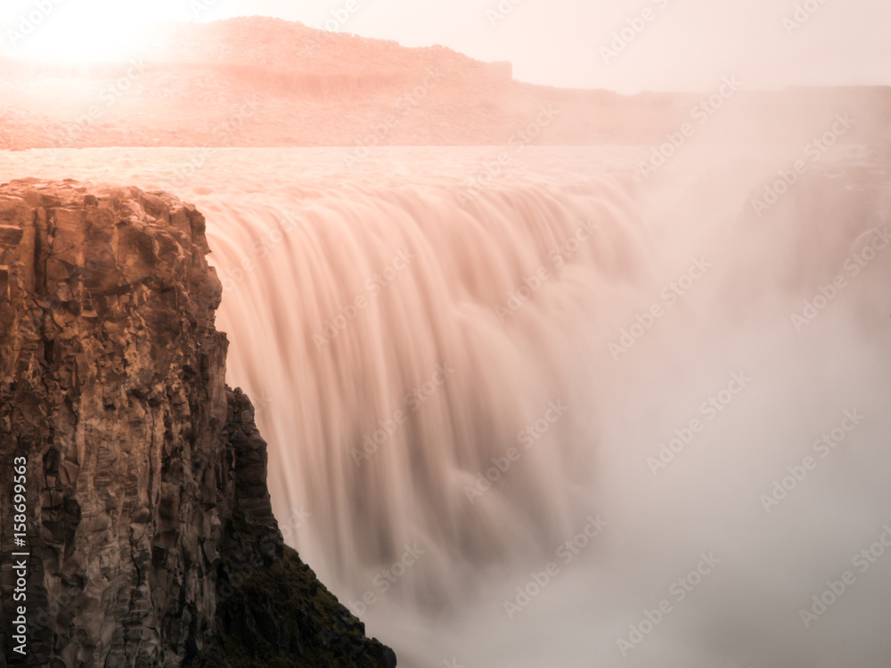 Detifoss waterfall illuminated by sunset, northern Iceland. Silk water effect by long exposure time.