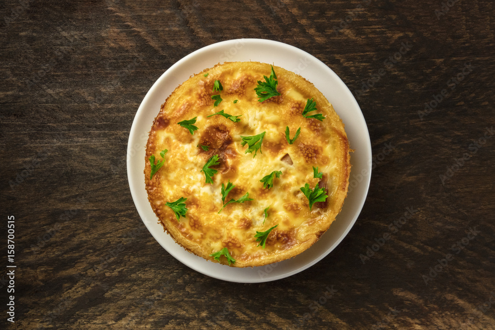 Overhead photo of French quiche on rustic texture Overhead photo of French quiche on rustic texture