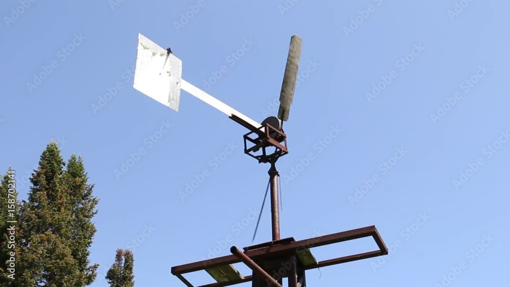 The windmill pumped water in Siberia against the blue sky. The windmill pumped water in Siberia against the blue sky.