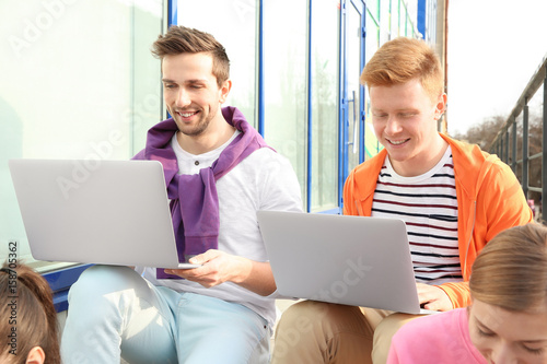 Young people with laptops s...