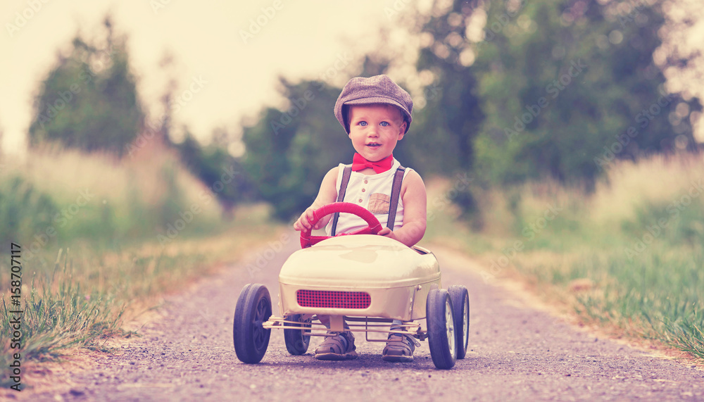 Kind fährt im nostalgischen Tretauto Kind fährt im nostalgischen Tretauto