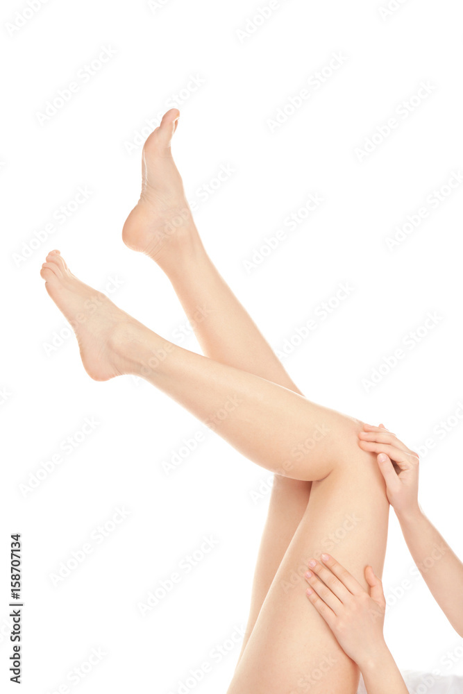 Epilation concept. Legs and hands of beautiful young woman on white background