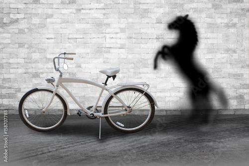 The concept of the hidden potential. Bicycle horse in the room which casts a shadow on the wall. The concept of world love and clean energy.