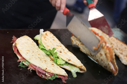 cook while cooking the piadina in the roaring grill of the outdo photo