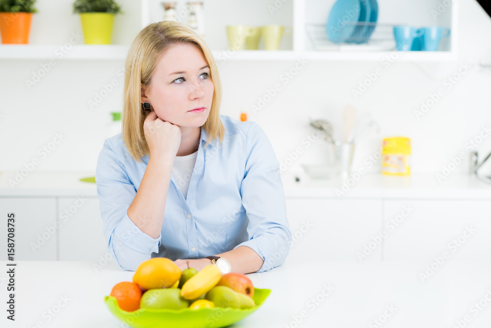Nachdenkliche junge Frau vor Obstschale Nachdenkliche junge Frau vor Obstschale