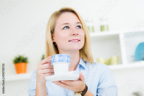 Junge nette Frau mit Tasse in Küche