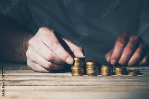 Stacking money coins, business casual man on table