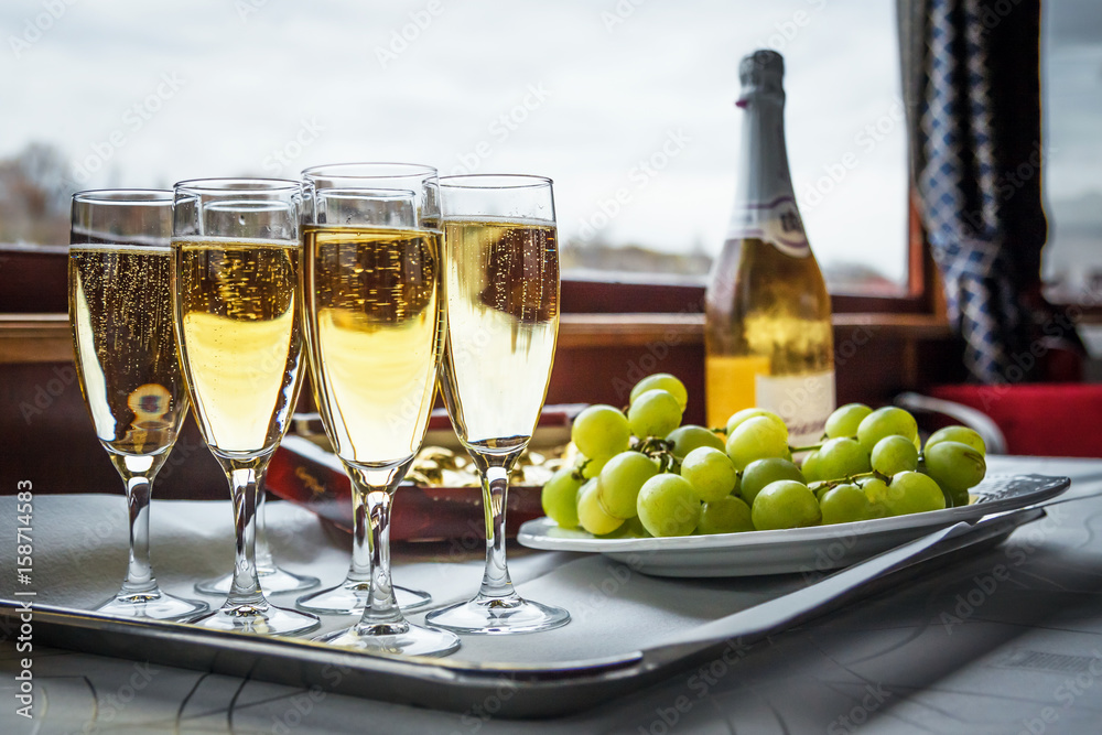 Champagne in glasses, bottle and grapes on the table Champagne in glasses, bottle and grapes on the table