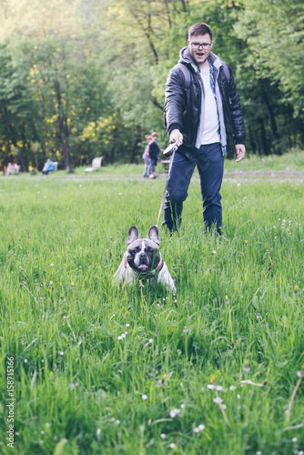 man walk with french bulldog in city park