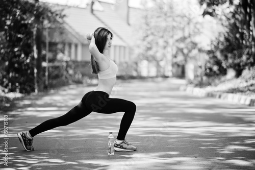 Fitness sport girl in sportswear with bottle of water doing exercise in the street, outdoor sports, urban style.