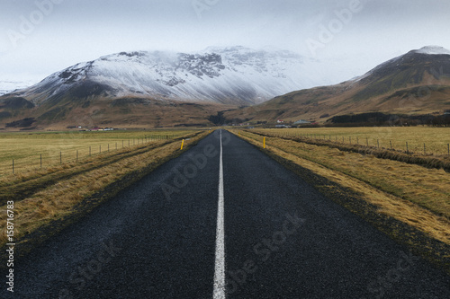 icelandic road with snow on mountains