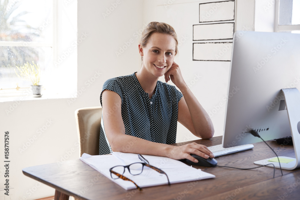 Obraz premium Smiling white woman working in an office looking to camera