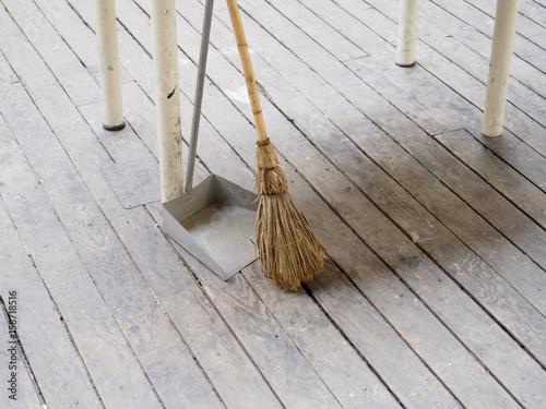 Broom and dustpan on old wood floor