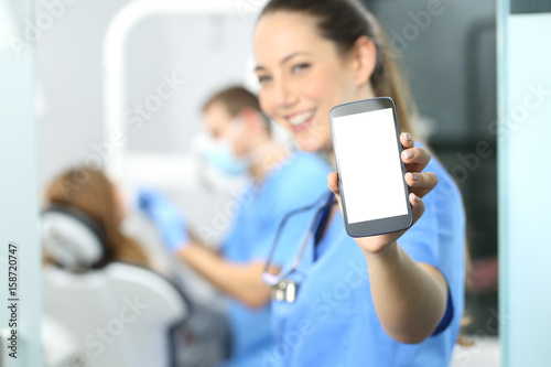 Female dentist showing phone screen