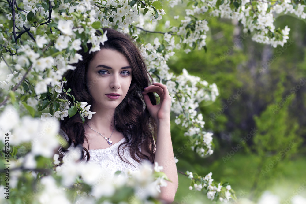 Portrait of a girl surrounded by white blossoming apple trees Portrait of a girl surrounded by white blossoming apple trees