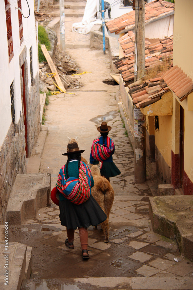 Péruvienne et lama dans une ruelle de Cusco au Pérou