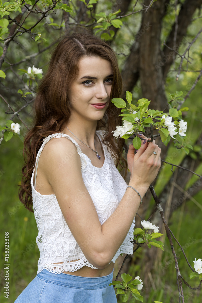 Portrait of a girl surrounded by white blossoming apple trees Portrait of a girl surrounded by white blossoming apple trees