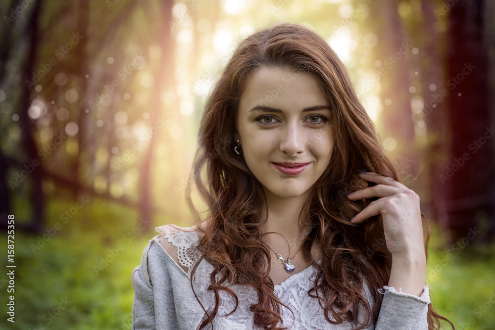 Girl with long hair in the park against the setting sun