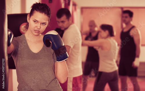 Sports girl beating boxing bag