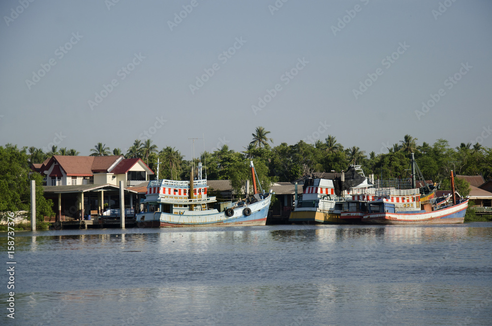 Wooden fishery boat floating and stop wait for go to catching fish in the sea in evening time at Mae klong river