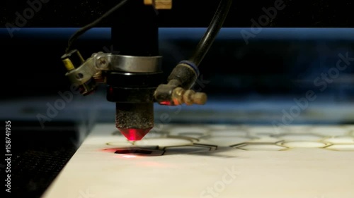 Side view laser cutting machine at work on wood