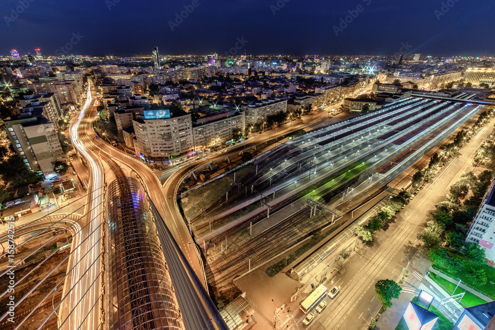 Fototapeta premium Aerial panorama of the Bucharest central train station - Bucharest Nord. Traffic and buildings after the sunset. 