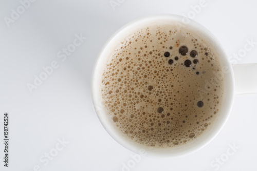 Top view of an isolated cup of Cappuccino coffee with some bubbles.