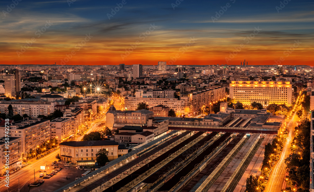Aerial panorama of the Bucharest central train station - Bucharest Nord. Traffic and buildings after the sunset.	