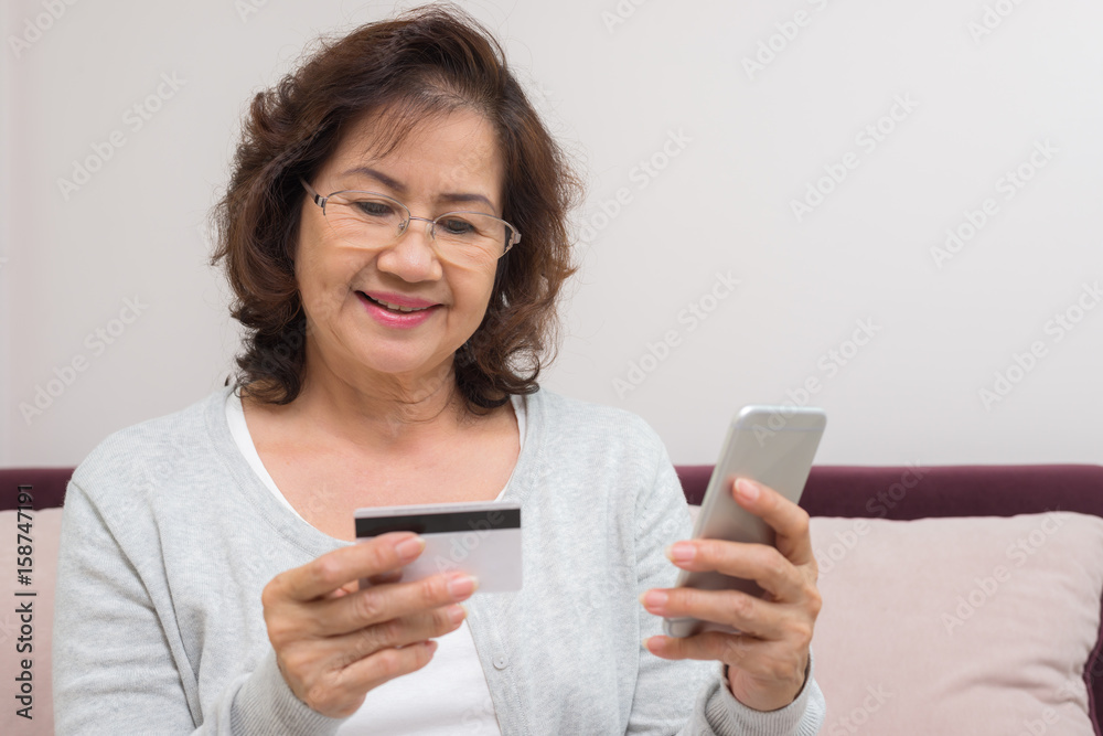 Happy Asian senior woman shopping online pay with credit card Happy Asian senior woman shopping online pay with credit card