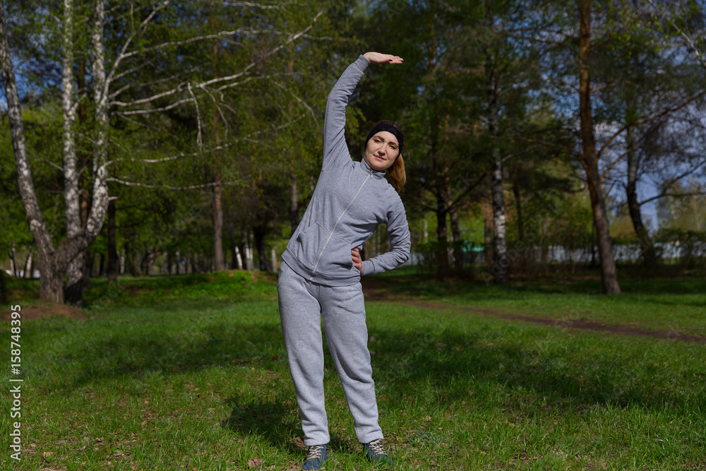 pretty young woman exercise in the park. fitness, sport, exercising, people and lifestyle concept. pretty young woman exercise in the park. fitness, sport, exercising, people and lifestyle concept.