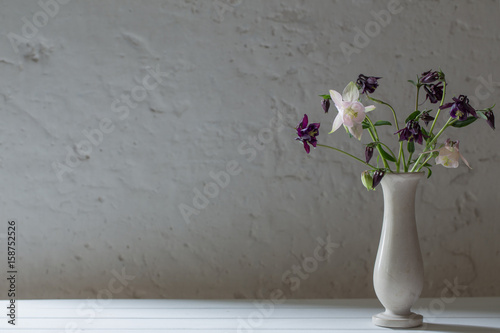 Foto flowers in vase on background old white wall