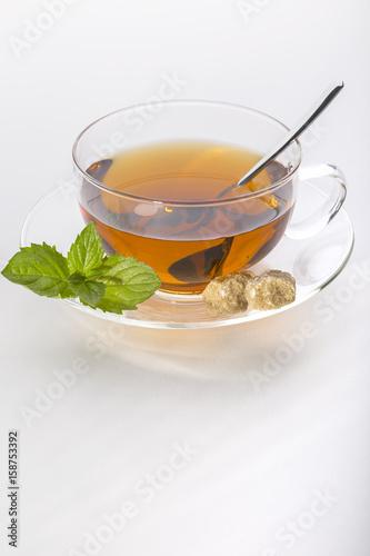 Tee mit Minze und Rohrzucker in der Glas-Teetasse